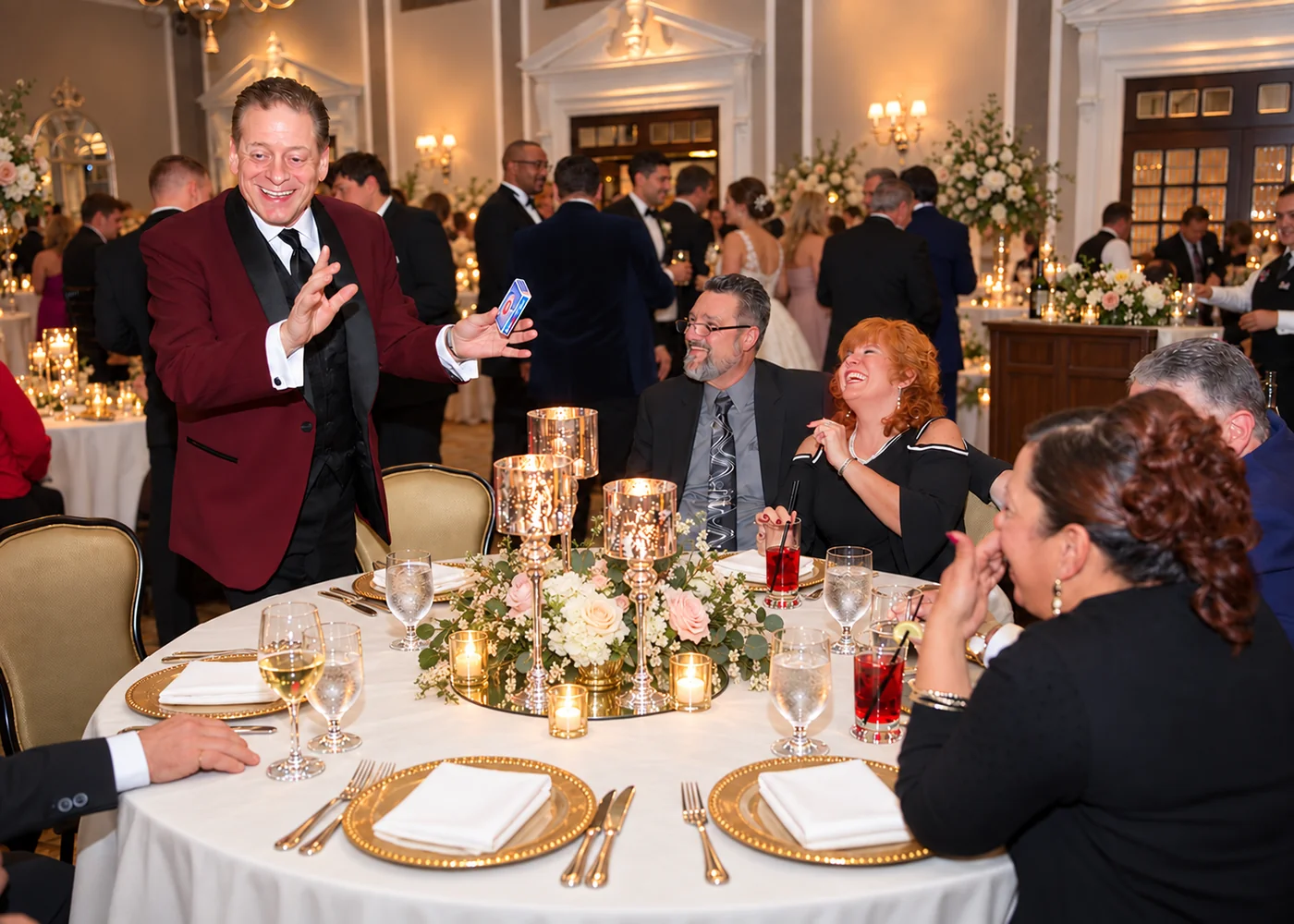 Mike Thornton entertaining smiling guests with card magic at an elegant wedding reception